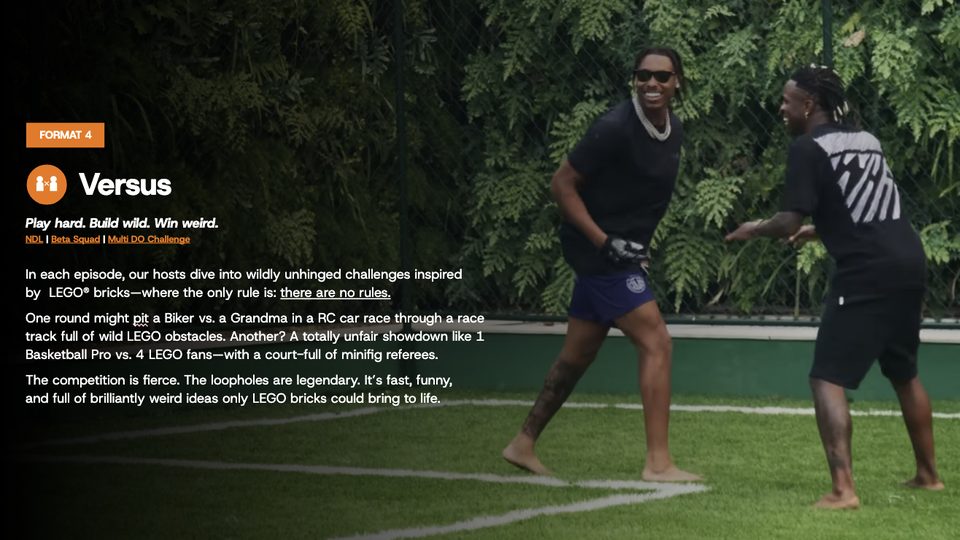 Two hosts facing off on a grass court during a LEGO challenge